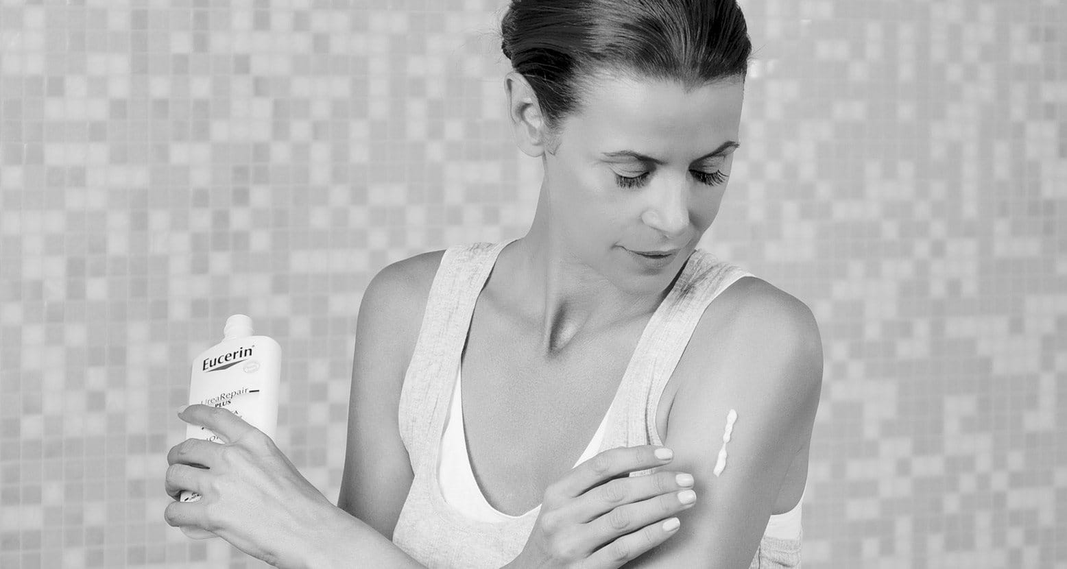Woman applying skin lotion