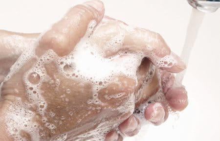 Hands getting washed with soap