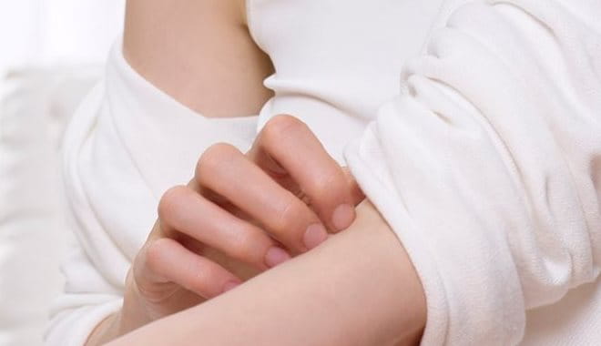 Inherited: Person scratching arm due to itchy skin