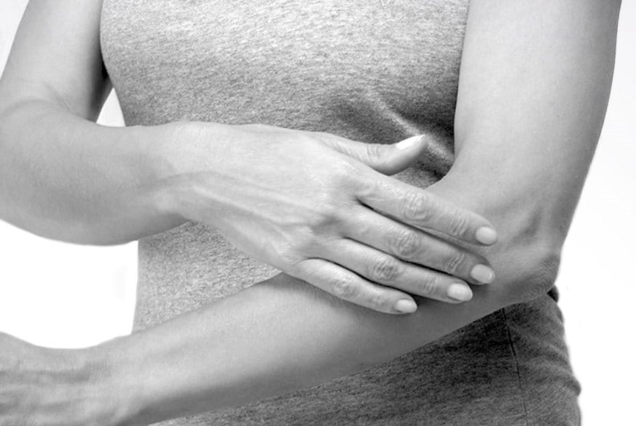 Woman applying cream on her arm