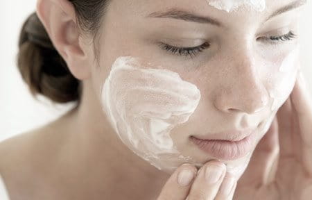 Woman using cleanser on her face