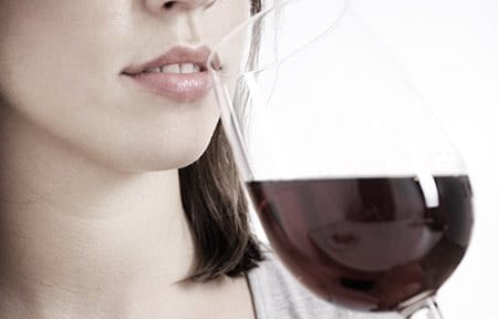Woman about to drink red wine.