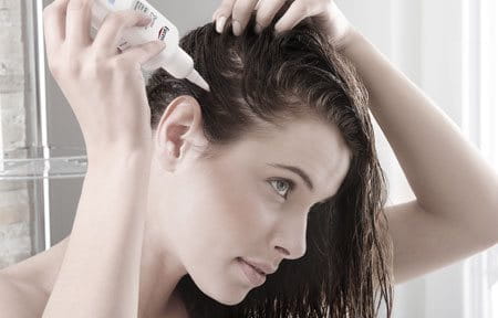 Woman using scalp treatment against dandruff