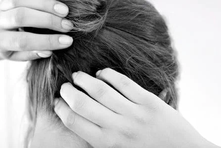 A woman scratching her itchy scalp