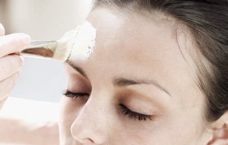 Peeling is applied on woman´s face with a brush.