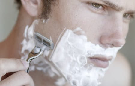 Man is wet shaving.