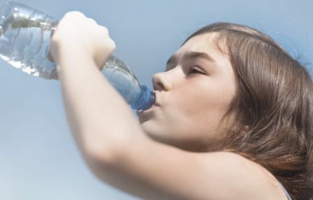 Kind in der Sonne trinkt Wasser