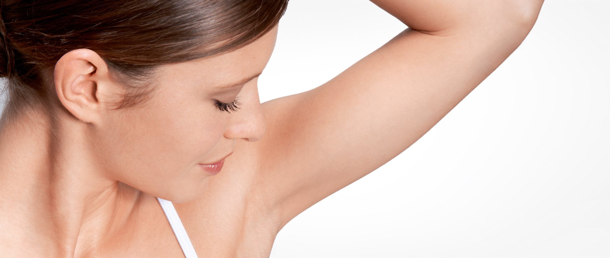 Woman examining underarm for deodorant intolerance.