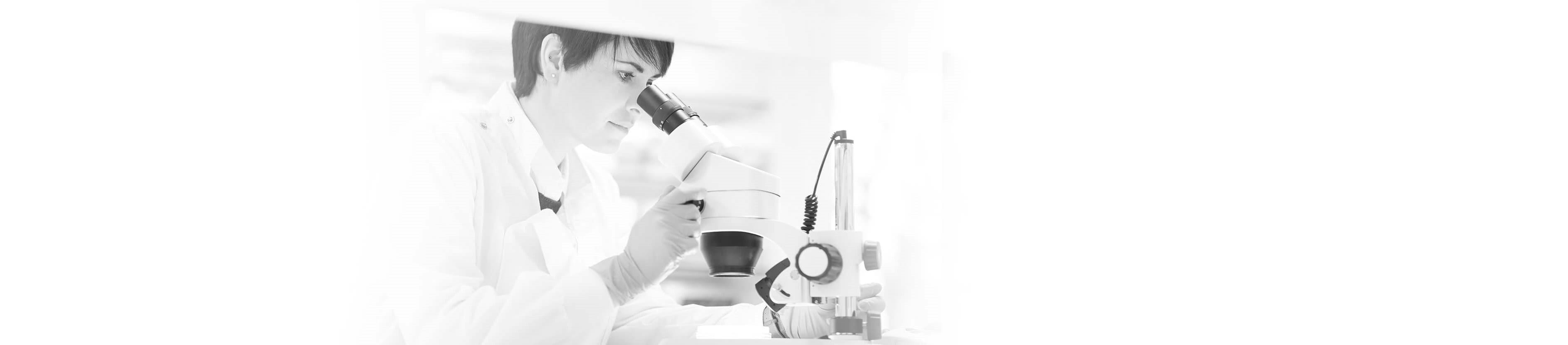 Frau sieht in Mikroskop