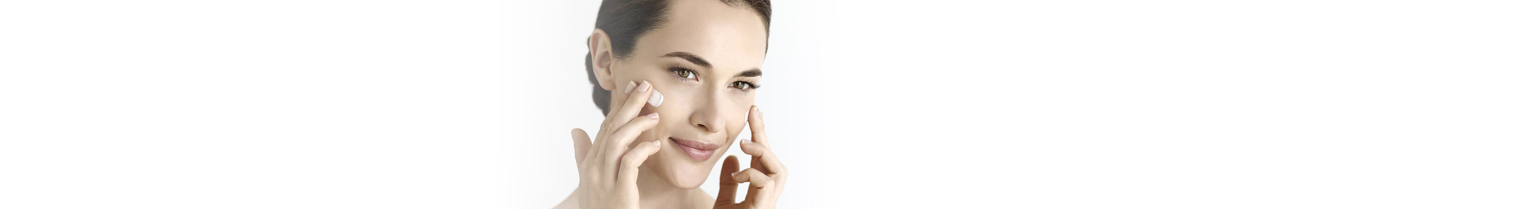 Frau cremt Gesicht ein