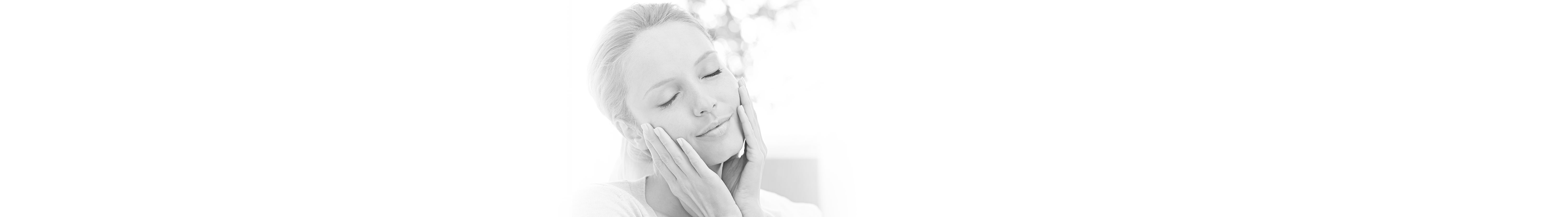 Junge Frau greift mit Händen sanft in ihr Gesicht 
