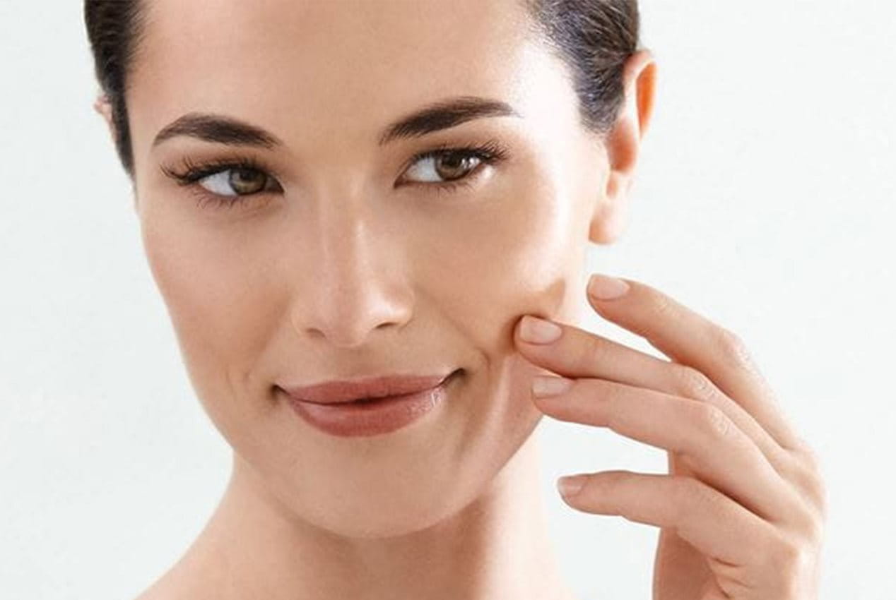 Frau betrachtet ihre Nasolabialfalte