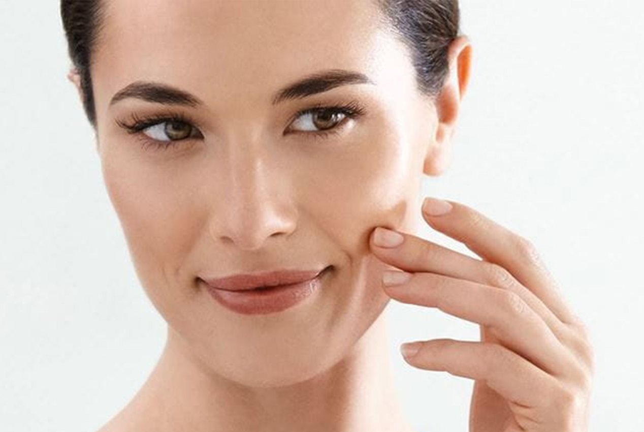 Frau betrachtet ihre Nasolabialfalte