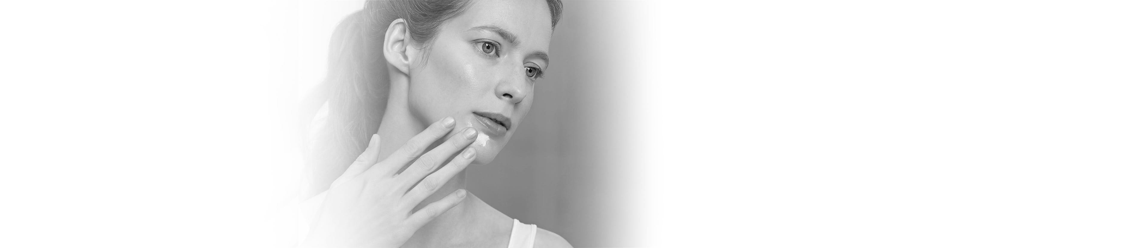 Frau greift sich mit Hand ins Gesicht