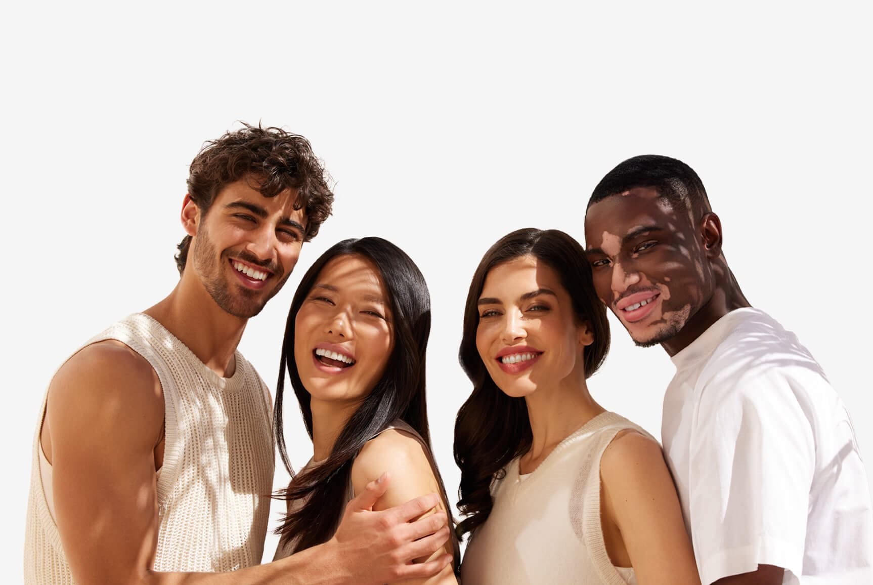 View of four people smiling while embracing each other and looking straight at the camera.