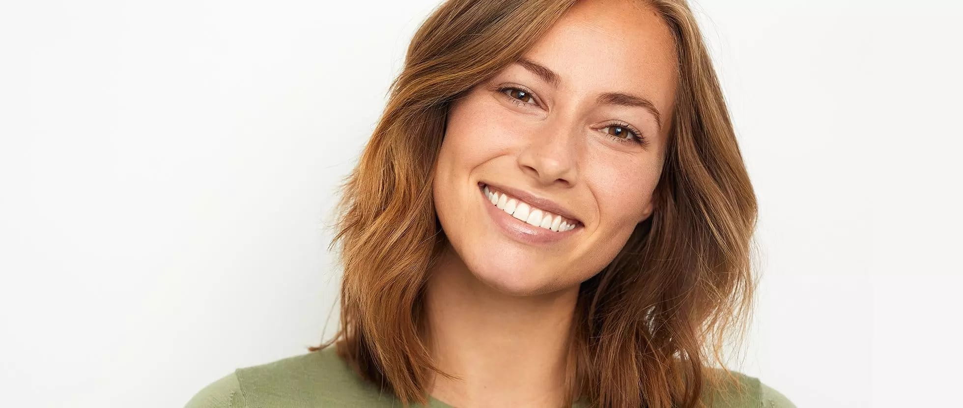 Sourire d'une femme avec des premières rides du visage, exprimant une beauté naturelle et une attitude positive.