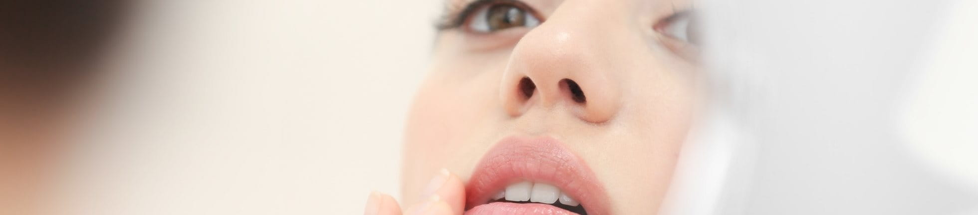 Frau mit perioraler Dermatitis im Spiegel