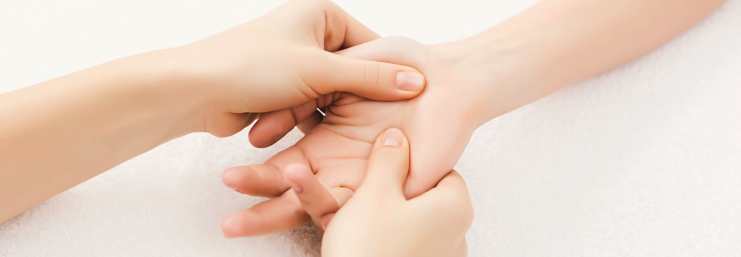 Eine weibliche Hand wird massiert