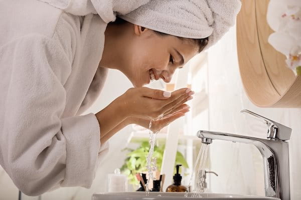 Frau wäscht Gesicht ab