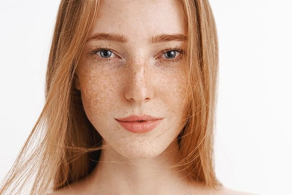 Rothaarige Frau mit Sommersprossen im Gesicht