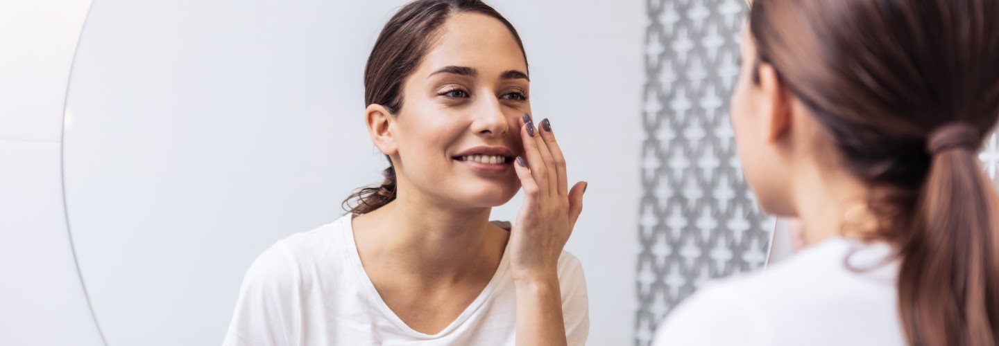 Junge Frau mit Mischhaut vor dem Spiegel