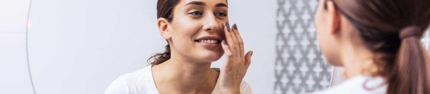 Junge Frau mit Mischhaut vor dem Spiegel