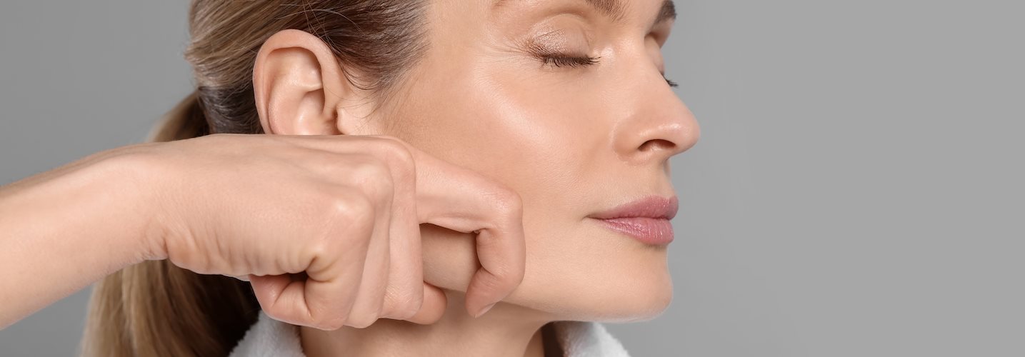 Eine Frau massiert ihr Gesicht