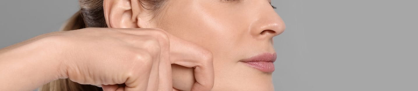 Eine Frau massiert ihr Gesicht