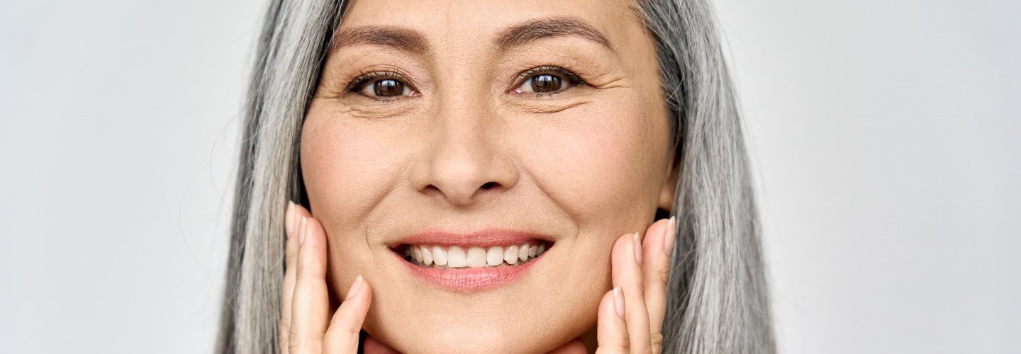 Nahaufnahme einer Frau mittleren Alters mit glatter Haut.