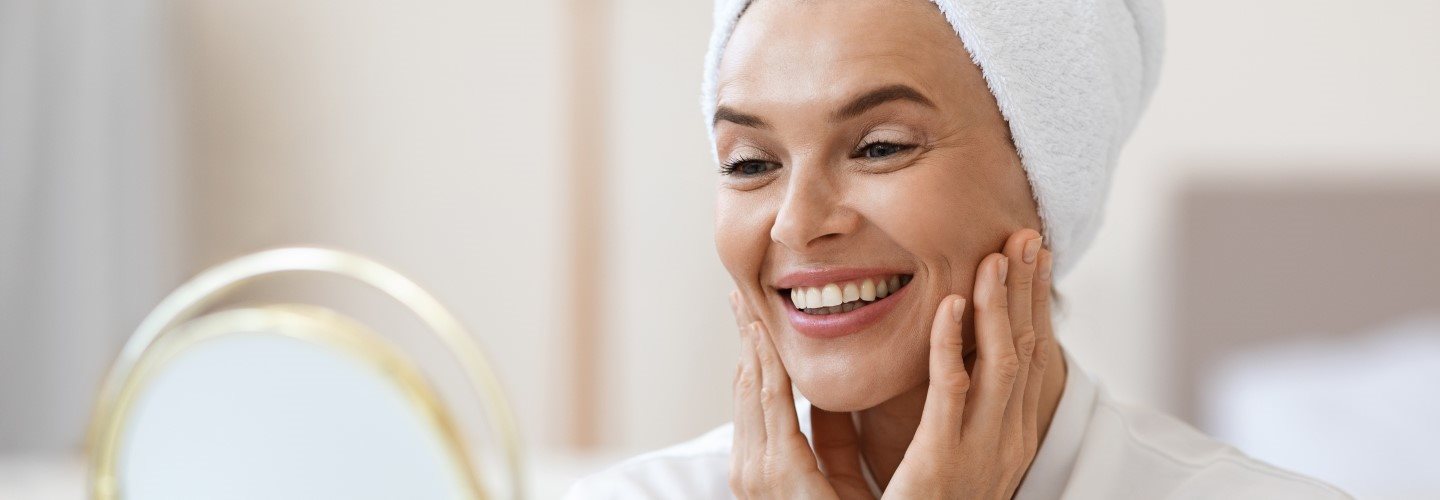 Nahaufnahme einer strahlenden Frau mittleren Alters.