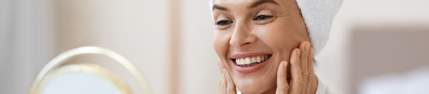 Nahaufnahme einer strahlenden Frau mittleren Alters.