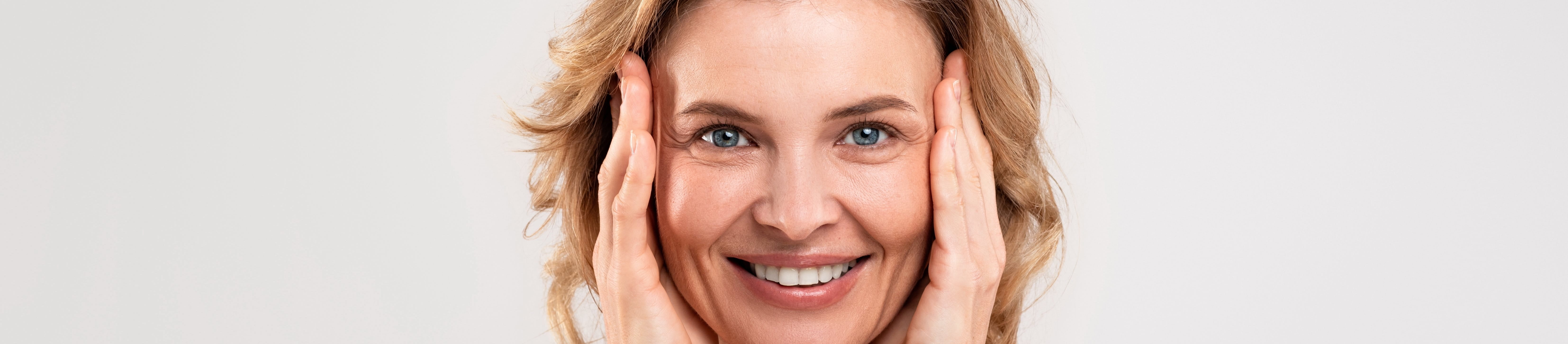 Frau mittleren Alters, die ihr Gesicht berührt