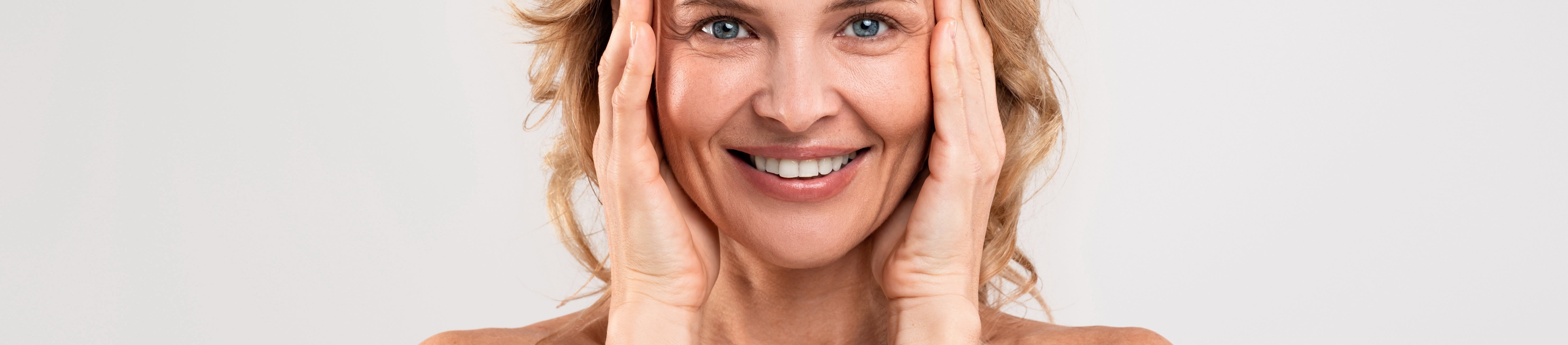 Frau mittleren Alters, die ihr Gesicht berührt