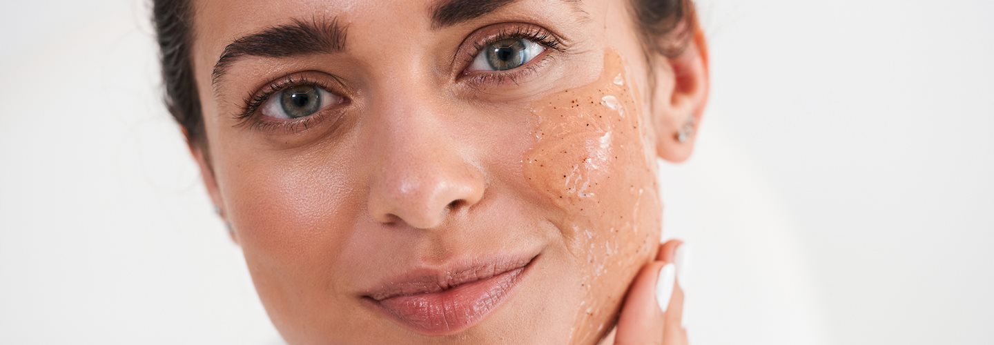 Frau trägt Glycolsäure-Peeling im Gesicht auf