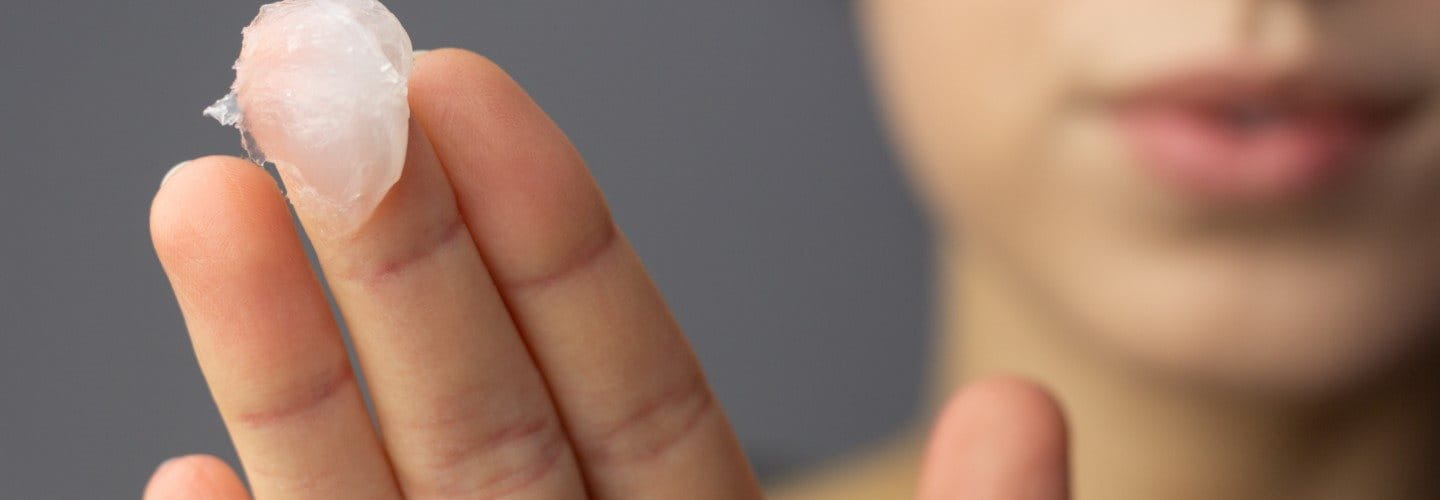 Eine Frau, die Slugging anwenden möchte und an ihrem Finger eine okklusive Salbe hat 