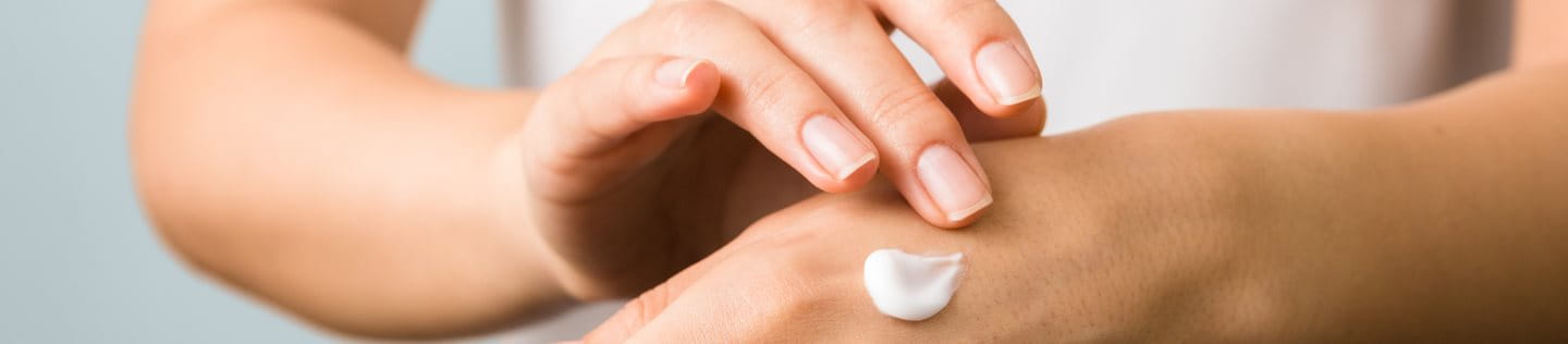 Nahaufnahme der Hand einer Frau, die Feuchtigkeitscreme aufträgt