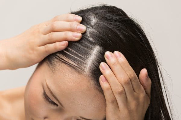 Eine Frau massiert die Kopfhaut