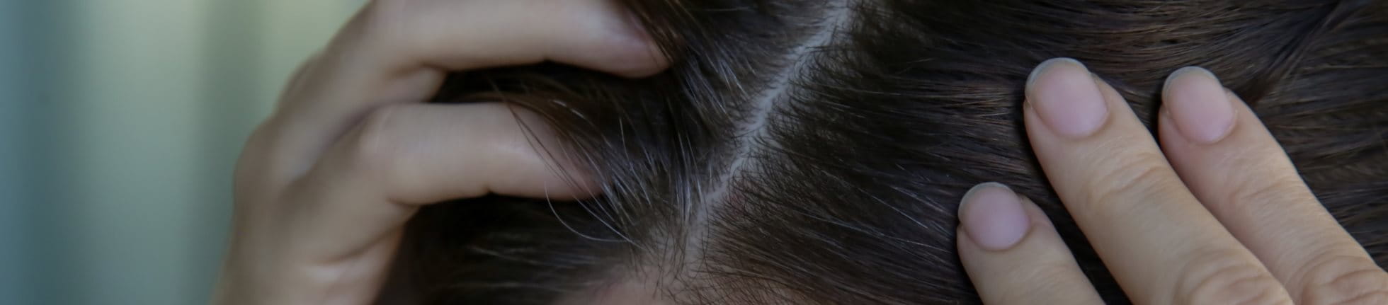 Frau betrachtet ihre Haare im Spiegel