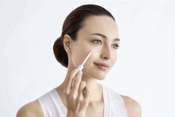 Frau trägt Thiamidol gegen Pigmentflecken auf