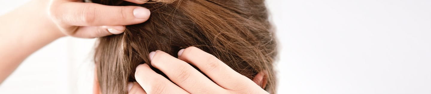 Frau kratzt sich am Hinterkopf