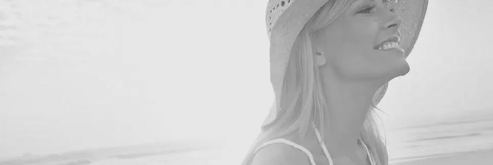 A woman at the beach wearing a sun hat