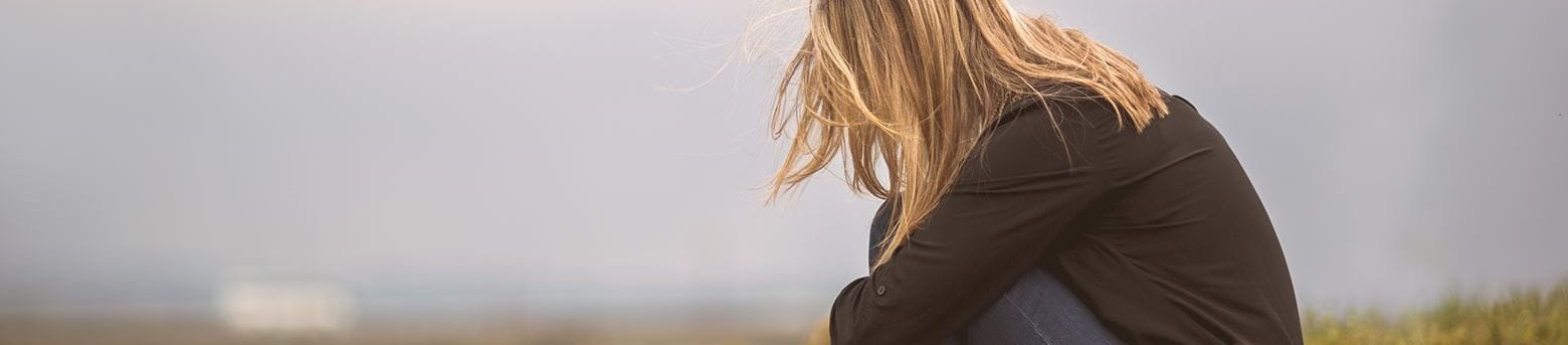 Sad woman sitting on a hill