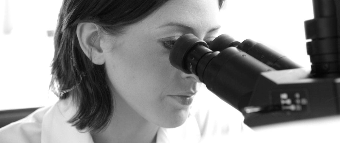 Woman looking through a microscope