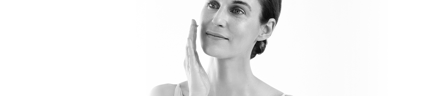 Woman applying lotion to her face