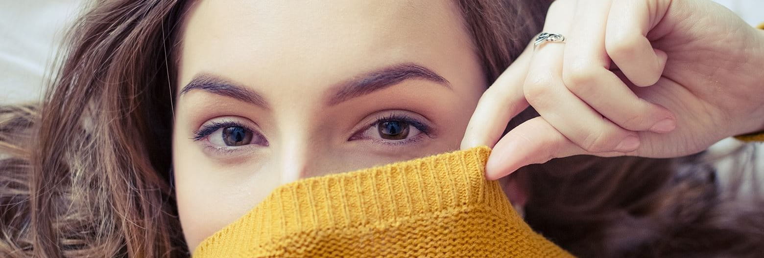 Woman covering the bottom part of her face with a sweater