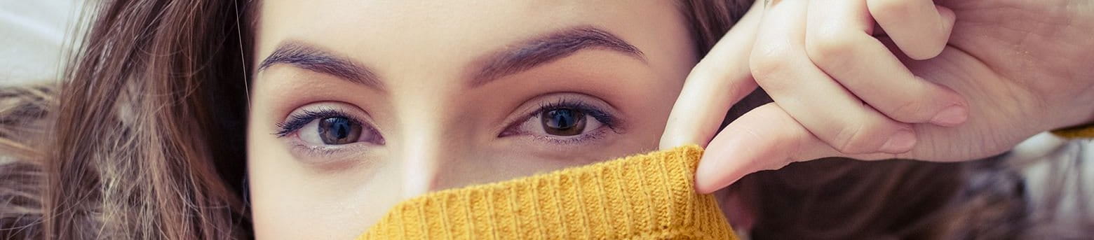 Woman covering the bottom part of her face with a sweater