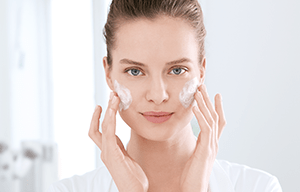 žena nanosi Eucerin DermoPure proizvode na masnu kožu lica