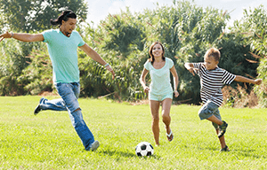 muškarac, žena i dijete igraju nogomet