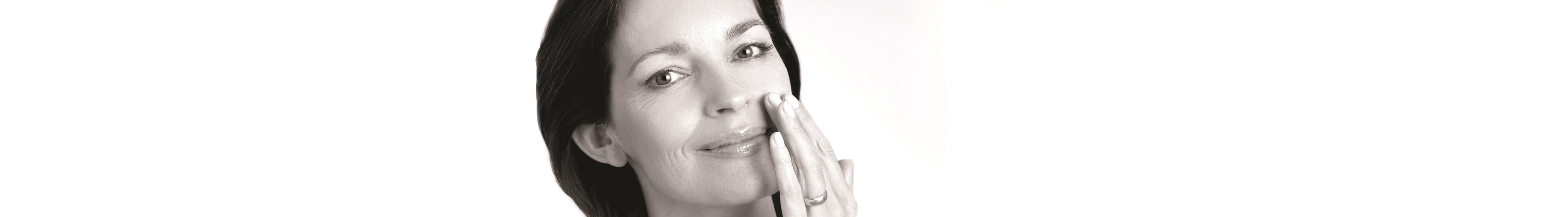 mulher de meia idade a tocar na bochecha com a mão