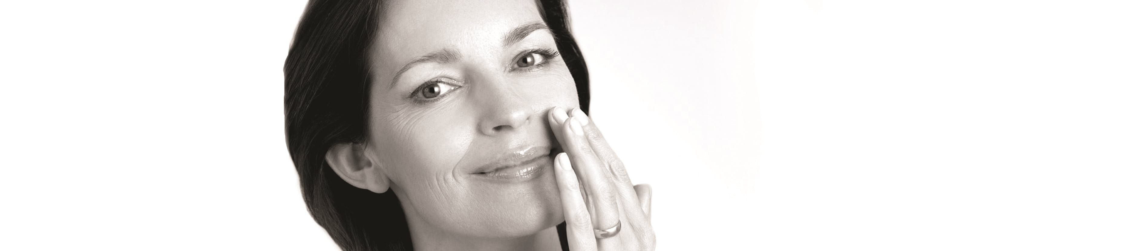 mulher de meia idade a tocar na bochecha com a mão